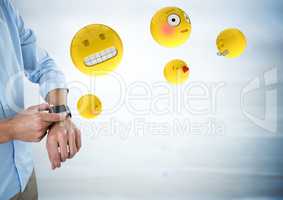 Business man mid section with watch and emojis with flare against blurry grey wood panel