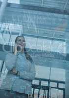 Business woman with phone and blue chart graphic overlay