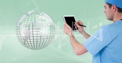 Doctor (men) using his tablet while he looks the 3D metallic earth