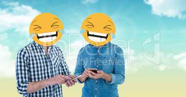 Digital composite of friends with laughing emojis on faces using smart phones
