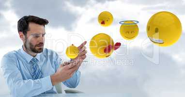 Digital composite image of businessman with emojis coming out from smart phone