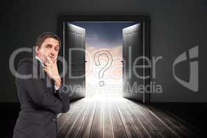 Confused businessman standing with door and question mark sign in background