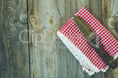 old kitchen knife on a red napkin, empty space on the left