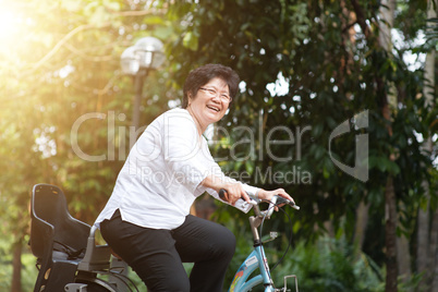 Elderly Asian woman biking