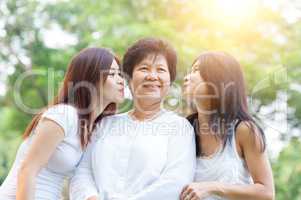 Daughters kissing mother