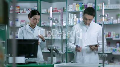 Two pharmacists working in pharmacy drugstore