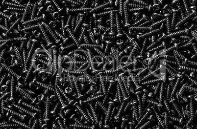 Background pile of shiny black screws
