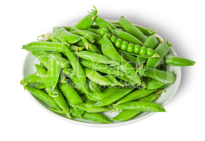 Big pile opening and closing pea pods on white plate