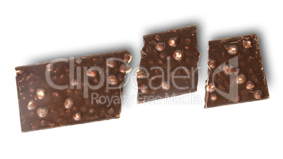 Broken tiles of dark chocolate with whole hazelnuts