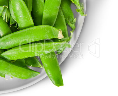 Closeup green peas in pods on white plate top view