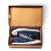 Dark blue sports shoes inside cardboard box