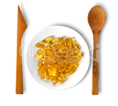 Fish oil on plate with wooden knife and spoon