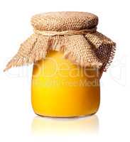 Honey in a glass jar covered with burlap