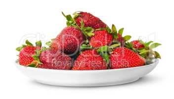 In front pile of fresh juicy strawberries on white plate