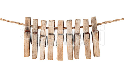 Many old wooden clothespins on a rope isolated