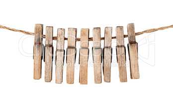 Many old wooden clothespins on a rope isolated