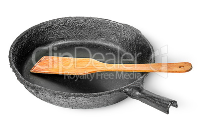 Old cast iron pan with wooden spatula