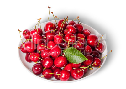 On top sweet cherries with leaf on white plate