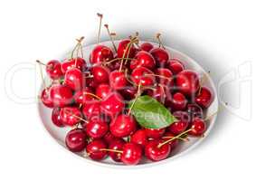 On top sweet cherries with leaf on white plate