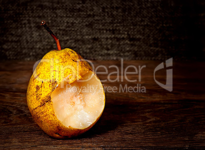 One bitten pear on a wooden table