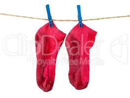 Pair of washed red socks on rope