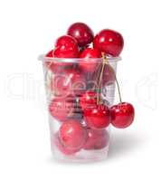 Red juicy sweet cherries in a plastic cup