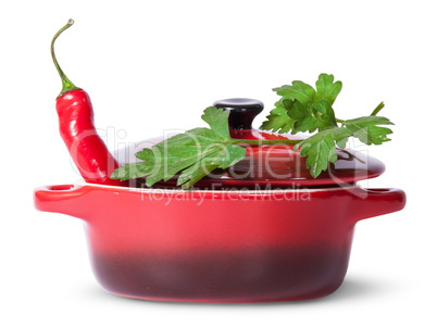 Red pepper in saucepan with lid and parsley on top