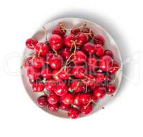 Red sweet cherries in white plate top view