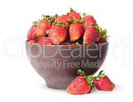 Ripe juicy strawberries in a ceramic bowl and two near