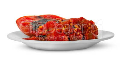 Rotting tomato on white plate