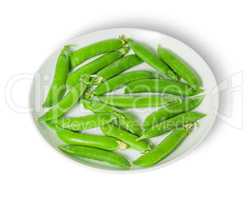 Several pods of peas on a white plate