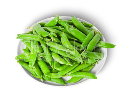 Small pile of green peas in pods on white plate