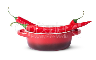 Three red chili peppers in saucepan