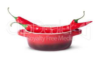 Three red chili peppers in saucepan