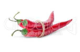 Three red chili peppers rotated tied with a rope