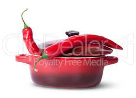 Two red chili peppers in saucepan with lid