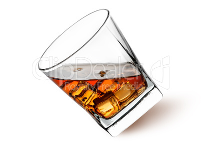 Whiskey with ice in a tilted glass