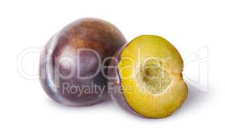Whole and half of violet plums near
