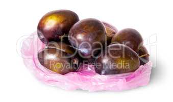 Whole violet plums in plastic bag
