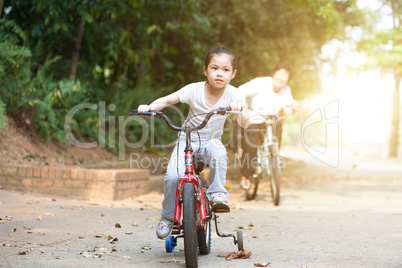 Grandmother and granddaughter riding bike outdoor.