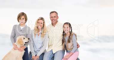 Happy family with dog siting against bright background