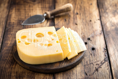 Delicious Swiss yellow cheese on dark wooden rustic background closeup