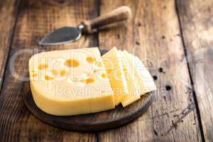 Delicious Swiss yellow cheese on dark wooden rustic background closeup