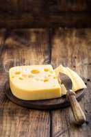 Delicious Swiss yellow cheese on dark wooden rustic background closeup