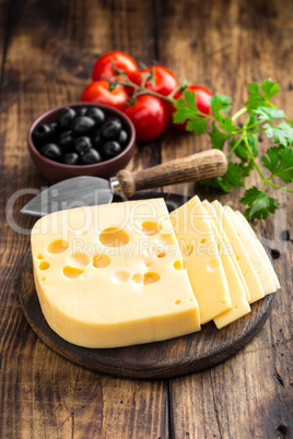 Delicious Swiss yellow cheese on dark wooden rustic background closeup