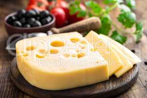 Delicious Swiss yellow cheese on dark wooden rustic background closeup