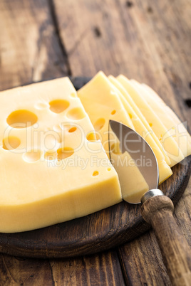 Delicious Swiss yellow cheese on dark wooden rustic background closeup