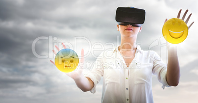 Woman in VR with network and emojis with flares against cloudy sky