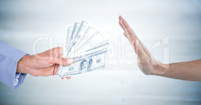 Hand refusing money against blurry grey wood panel