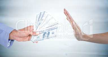 Hand refusing money against blurry grey wood panel